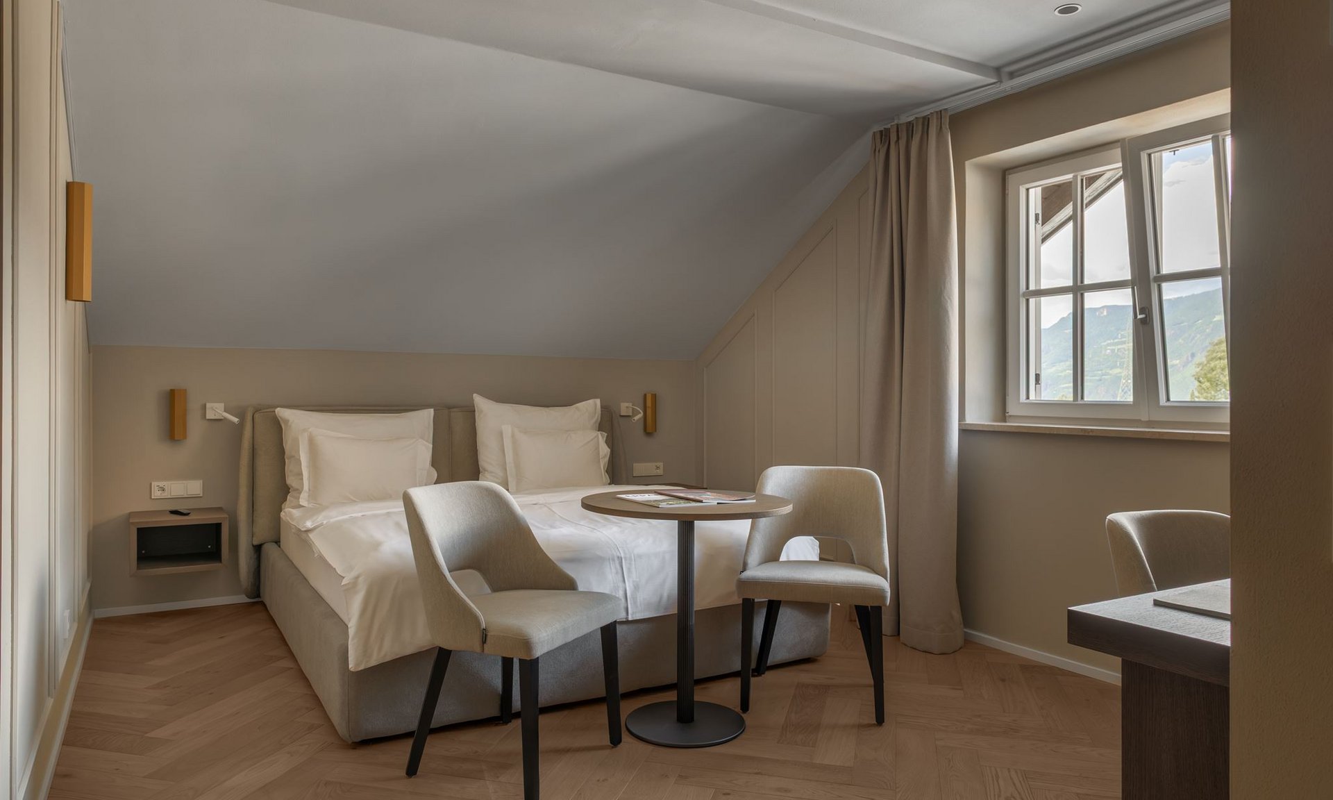Lingers’ best snapshots Bright hotel room with double bed, two chairs, and table near window