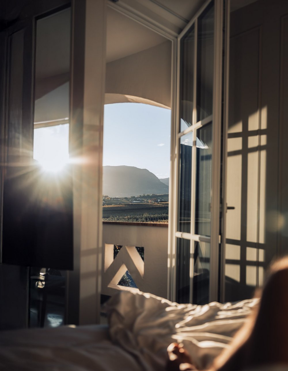 Lingers – Ihr Hotel in Girlan Sonnenaufgang auf einem Balkon mit Bergblick vom Bett aus