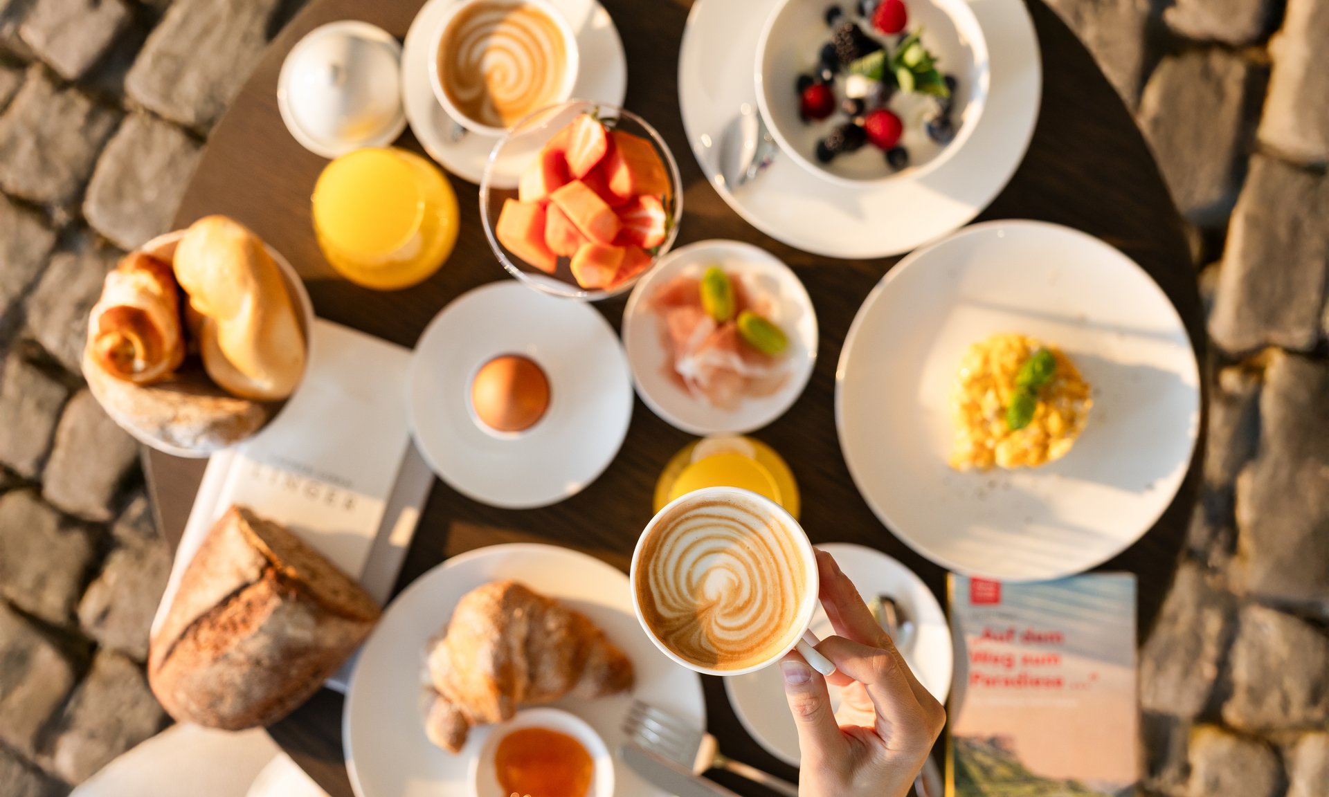 Lingers’ best snapshots Breakfast table with coffee, rolls, eggs, juice, and fresh fruit.