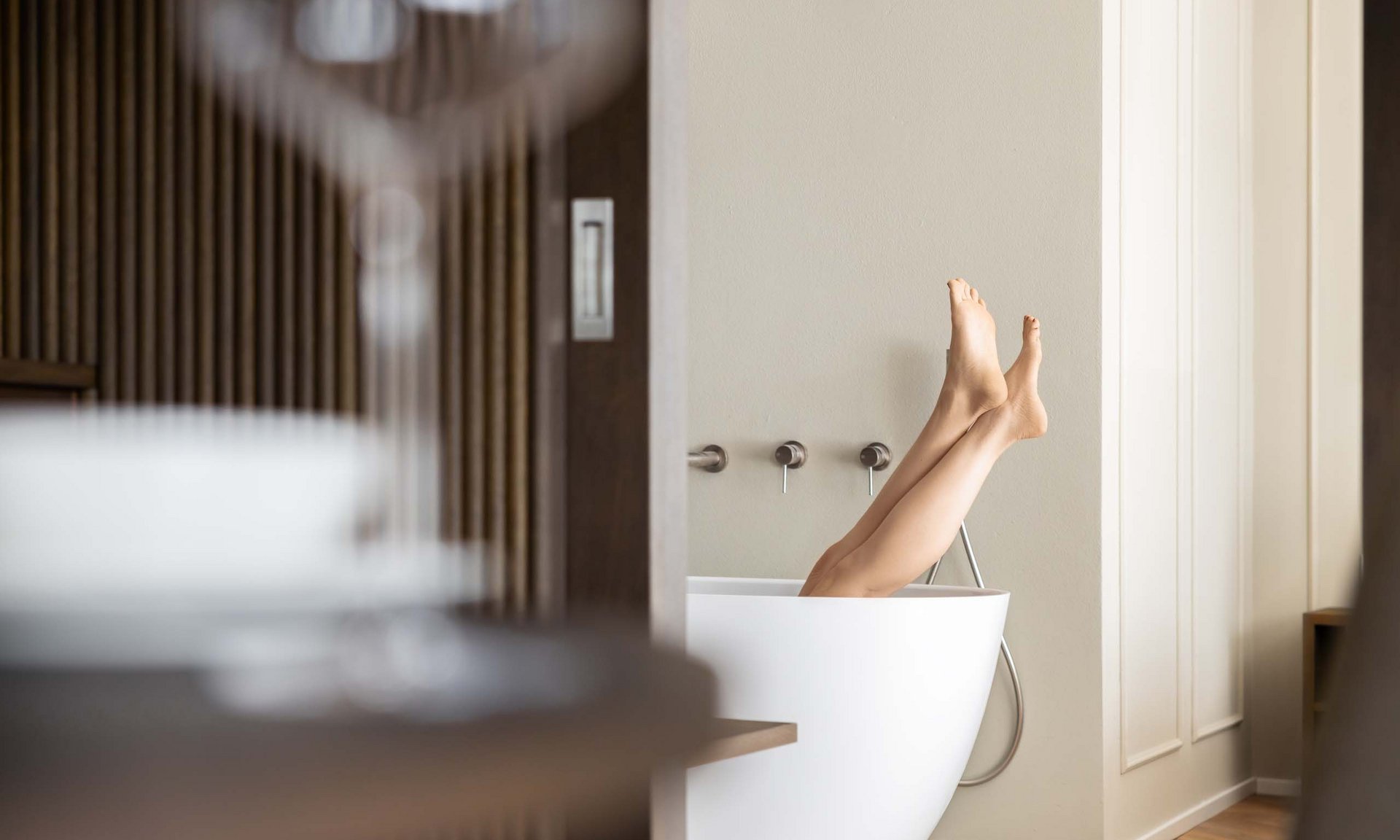 Lingers’ best snapshots Legs sticking out of a white bathtub in a modern bathroom