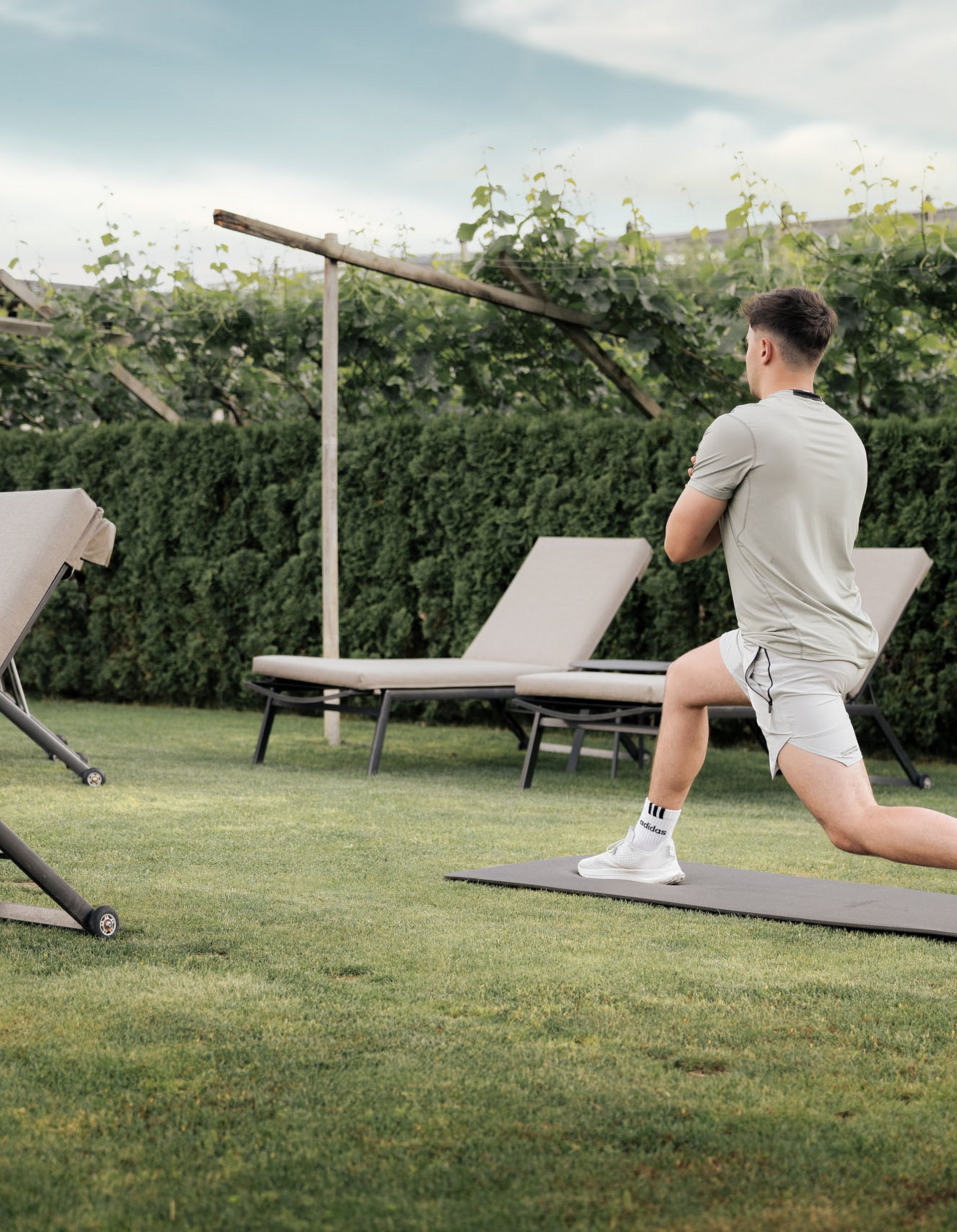 Lingers’ best snapshots Man stretching on mat in garden near lounge chairs
