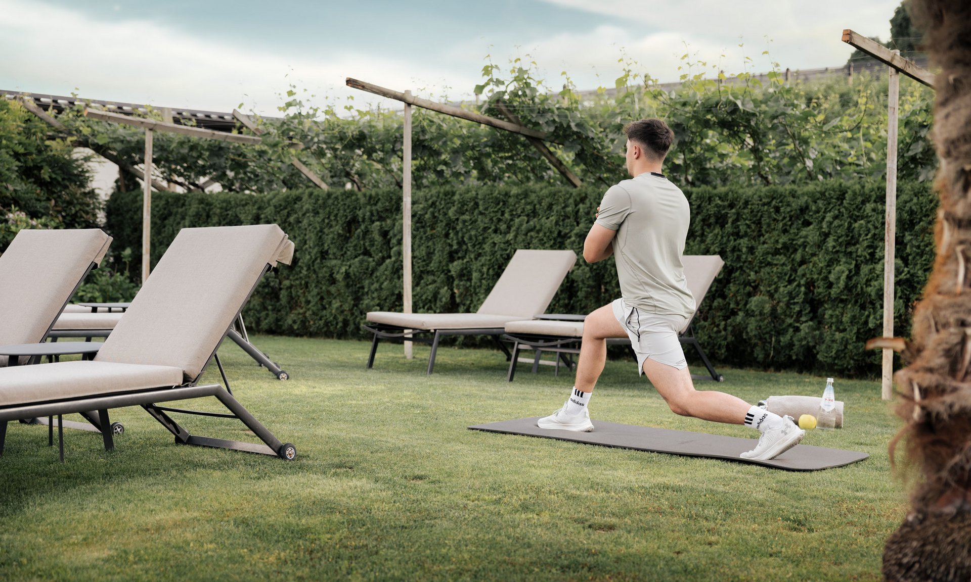 Lingers’ best snapshots Man stretching on mat in garden near lounge chairs