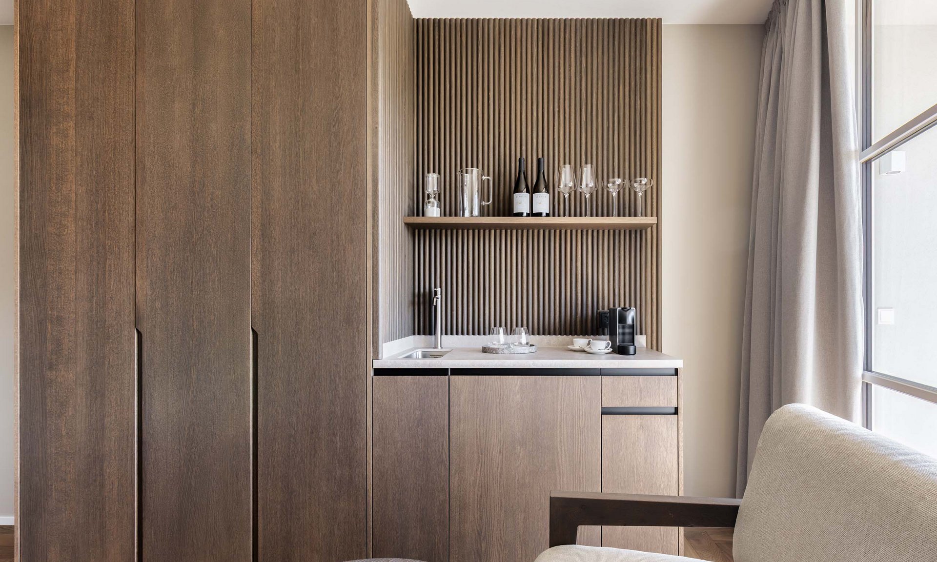 Lingers’ best snapshots Modern kitchenette with wooden cabinets, coffee machine, and glasses on the shelf