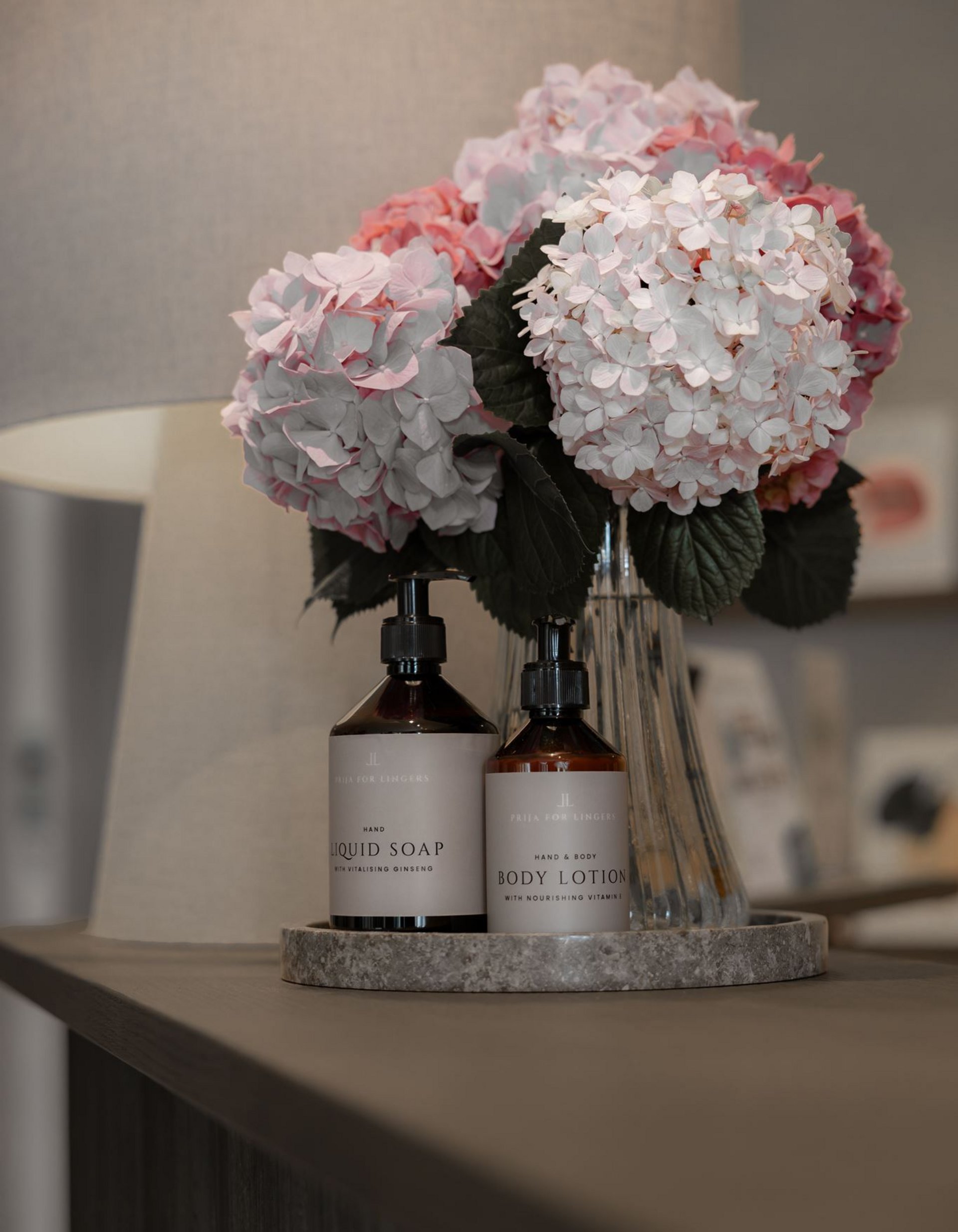 Lingers’ best snapshots Bottles of liquid soap and body lotion next to a vase with pink hydrangeas