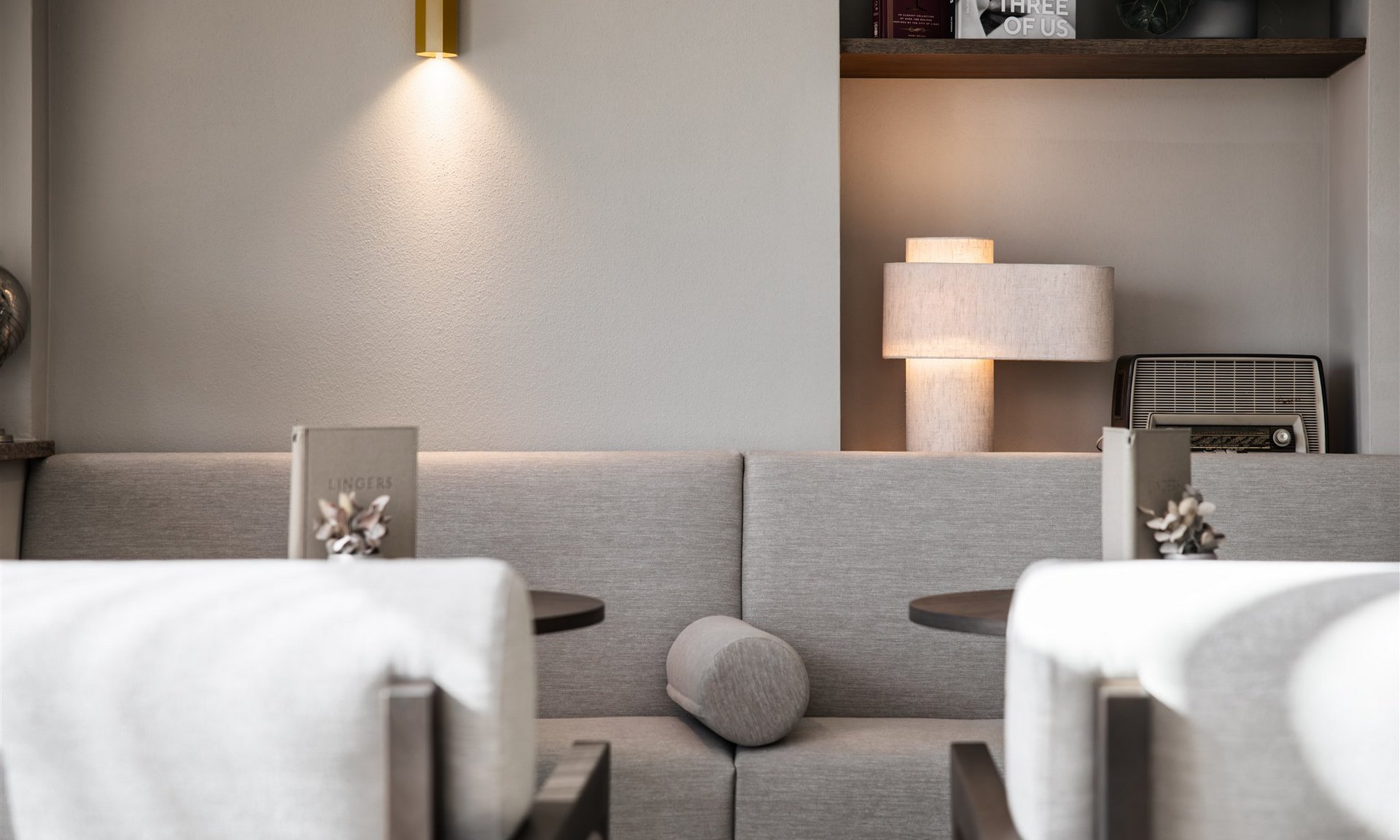 Lingers’ best snapshots Modern seating area with grey sofa, two tables, and soft lighting
